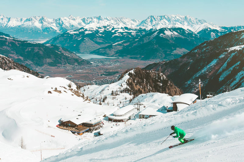 Skifahrer im Hintergrund ist eine Hütte zu sehen